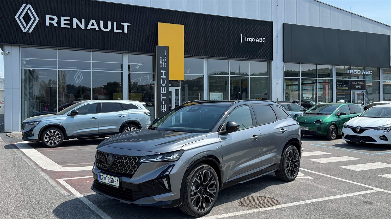 Stavba prodajnega salona Renault, parkirani avtomobili na parkirišču.