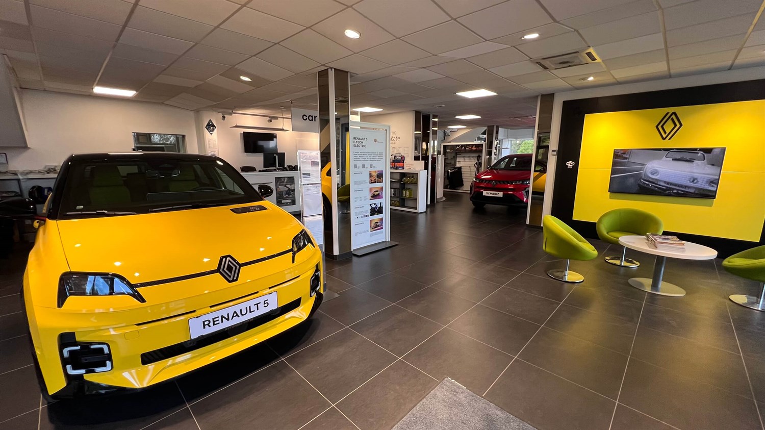 Notranjost poslovalnice Vrtin z rumenim Renault vozilom, razstavnim prostorom in sedežnim kotičkom.