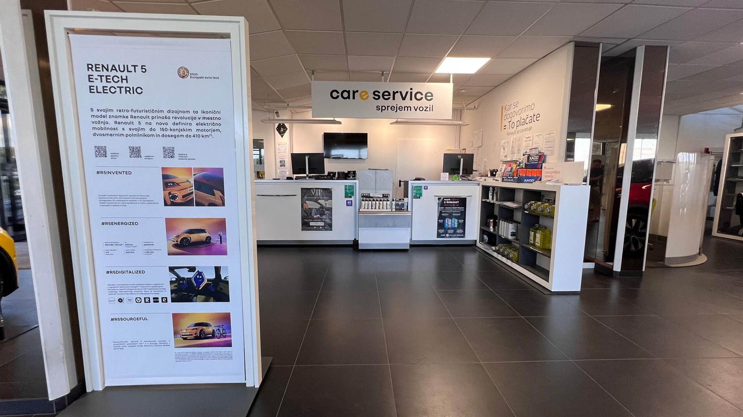 Sprejemni prostor za servis v poslovalnici Vrtin z informacijskim pultom in prikazi storitev.