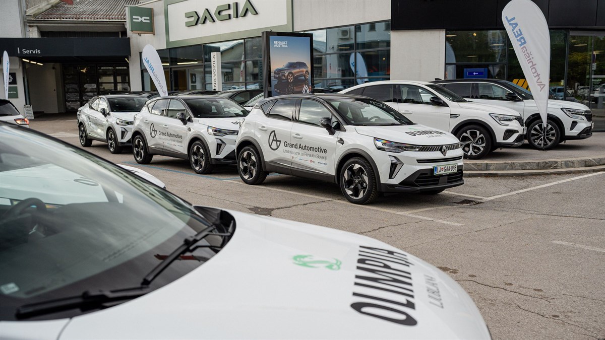 Flota novih električnih vozil Renault Megane E-Tech, označenih z logotipom KK Olimpija Ljubljana, parkiranih pred stavbo Dacia v Ljubljani.