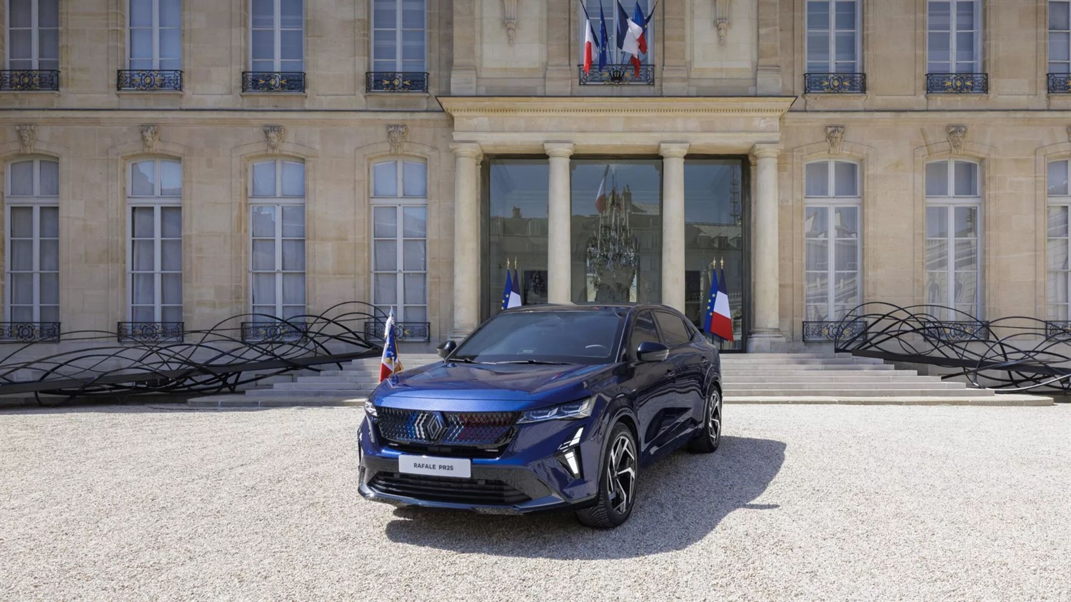 Renault Rafale pred palačo s francoskimi zastavami.