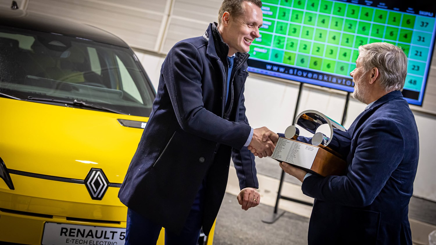 Renault 5 v studijskem okolju priklopljen na stoječo polnilnico. 