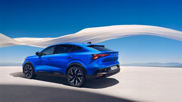 Moder Renault Rafale, parkiran na beli površini, v ozadju z belo tkanino, ki plapola v vetru.