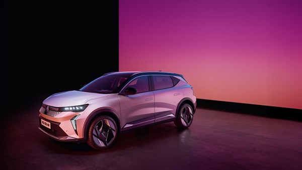 Beli Renault Scenic E-Tech parkiran v prostoru z vijolično-roza osvetlitvijo.