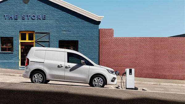 Bel Renault Kangoo, parkiran ob polnilnici pred modro stavbo z napisom "THE STORE".