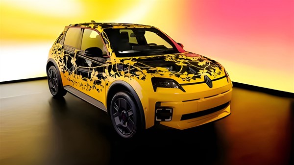 Rumeni Renault 5 E-Tech electric z umetniškim grafičnim vzorcem na studijskem ozadju.