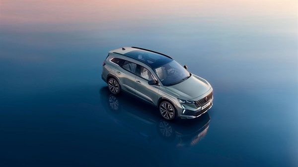 Sivi Espace parkiran na zrcalni vodni površini ob sončnem zahodu.