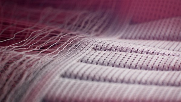 Detajl tekstila sedeža z vidnimi vlakni in šivi.