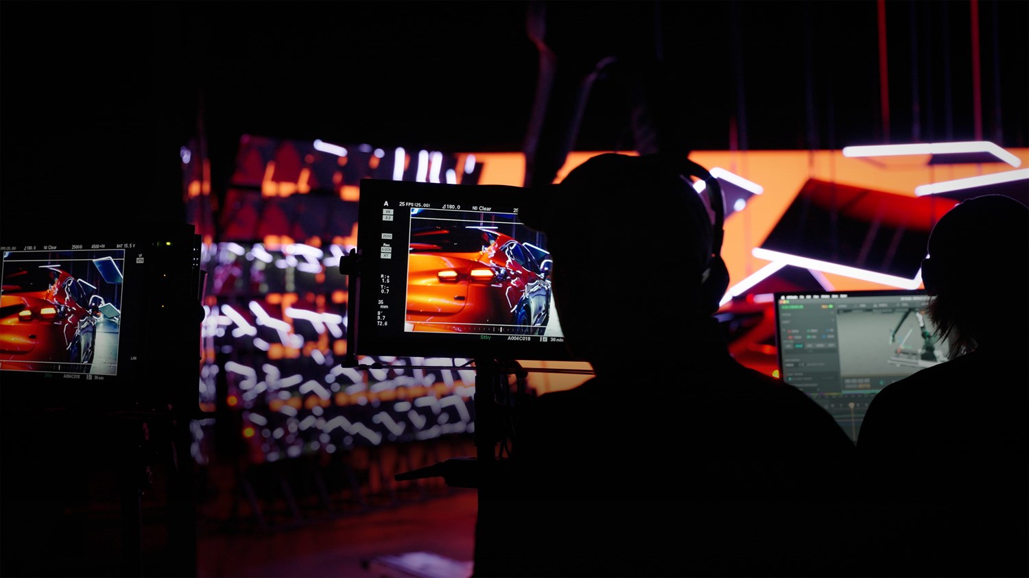 Osebi pred zasloni spremljata montažo oglasa za vozilo Renault.