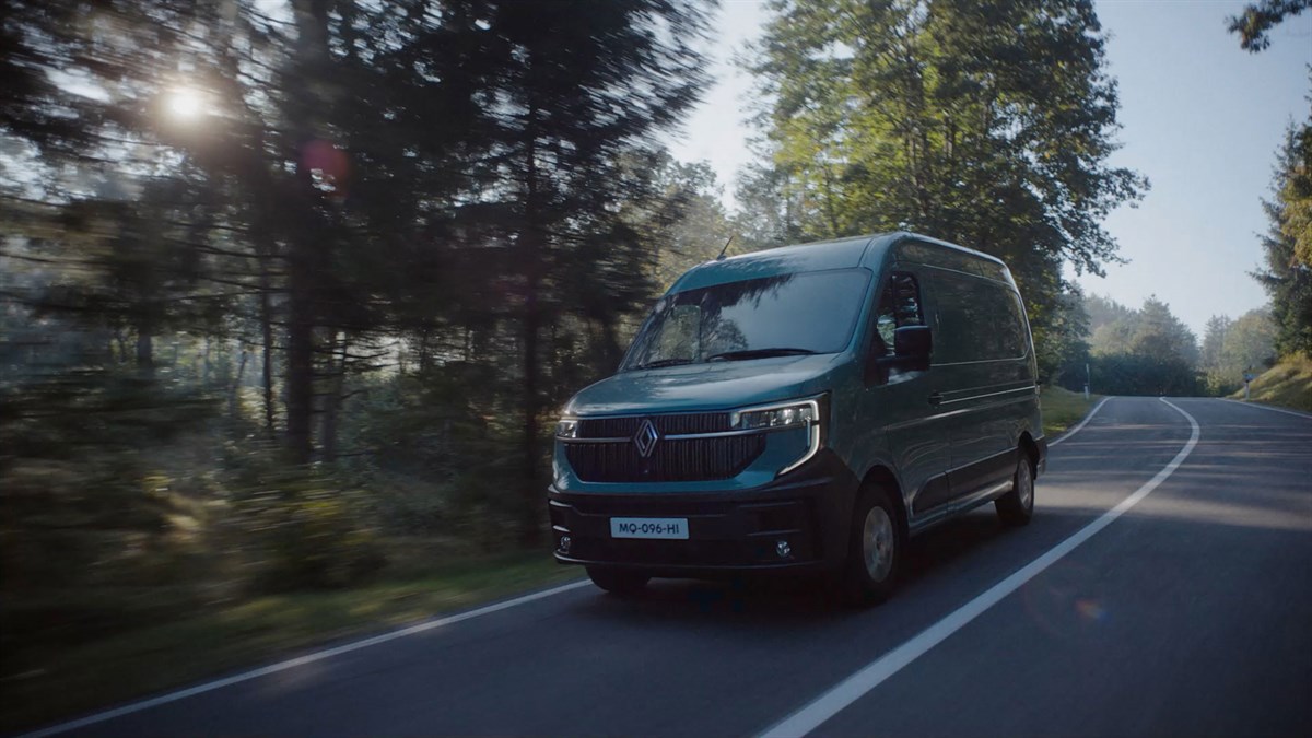 Sivi Renault Master med vožnjo po gozdni cesti.