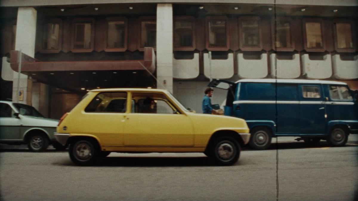 Klasični Renault 5 parkiran pred mestno stavbo.