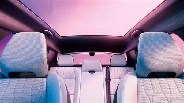 Zadnji del notranjosti Renault s panoramsko stekleno streho in svetlimi sedeži.