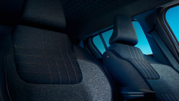 Notranjost Renault vozila, sedeži iz temne tkanine z oranžnimi šivi.
