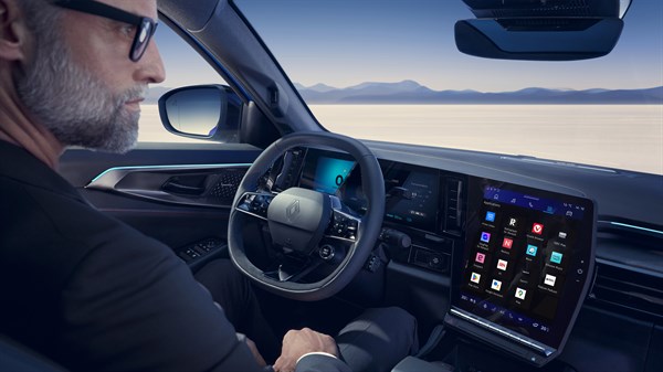 Renault vozilo notranjost z velikim zaslonom na dotik in voznikom za volanom.