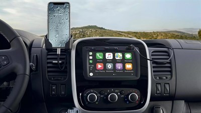 Armaturna plošča vozila z osrednjim zaslonom na dotik z Apple CarPlay™ in pametnim telefonom, pritrjenim na nosilec.