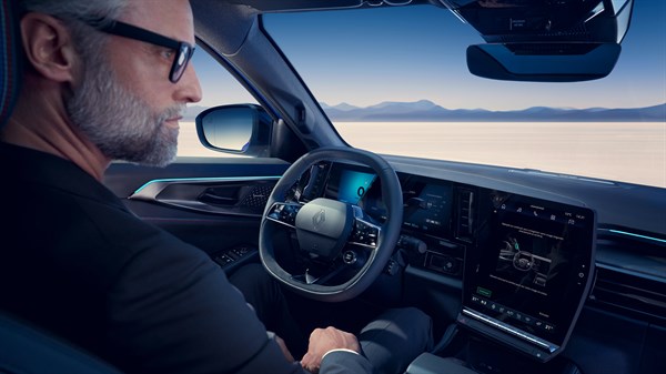 Voznik za volanom Renault Rafale z digitalno armaturno ploščo in velikim osrednjim zaslonom.