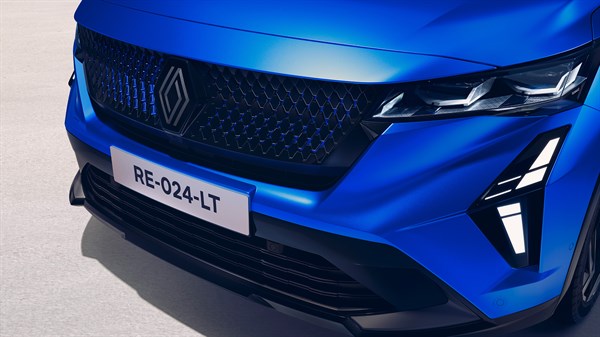 Detajlni pogled na sprednji del vozila Renault Rafale v modri barvi, ki prikazuje Renault masko, izstopajočo športno mrežo hladilnika, ostro oblikovana LED žarometa in dnevne luči.