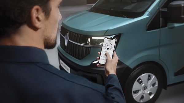 Moški upravlja aplikacijo na pametnem telefonu za povezljivost z dostavnim vozilom Renault Master, prikazan je prednji del električnega vozila.