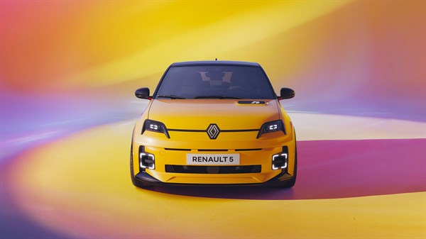 Sprednji pogled na rumeni Renault 5 E-Tech, postavljen na barvitem ozadju.