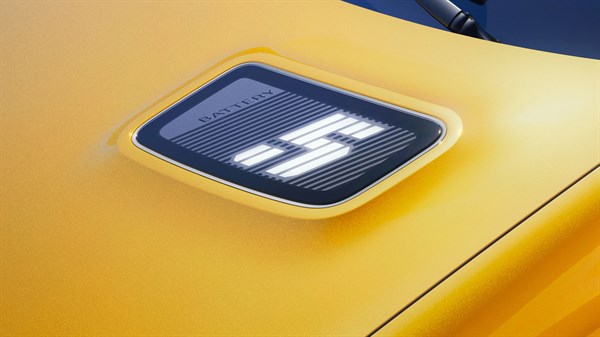 Pokrov baterije z osvetljenim logotipom "5" na pokrovu motorja rumenega Renault 5 E-Tech.