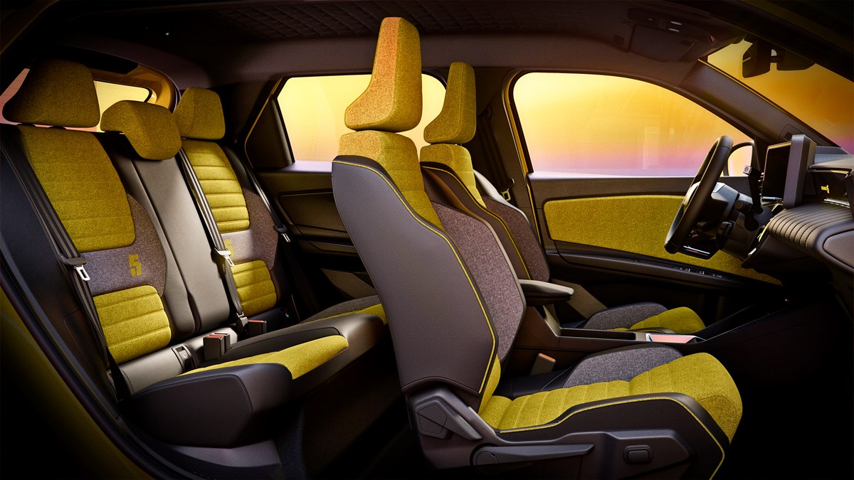 Notranjost Renault 5 E-Tech z rumeno-črnimi tekstilnimi sedeži in digitalnim kokpitom.