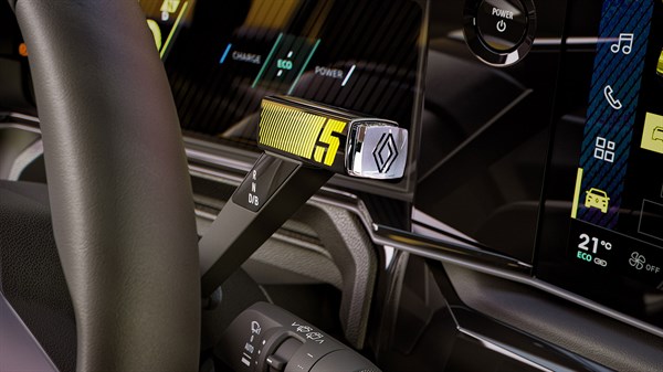e-pop prestavne ročice ob volanu v vozilu Renault 5 E-Tech z digitalnimi merilniki v ozadju.