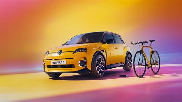Renault 5 E-Tech z električnim kolesom ob njem, prikazan v okolju z uporabo tehnologije Power to Object za polnjenje naprav.