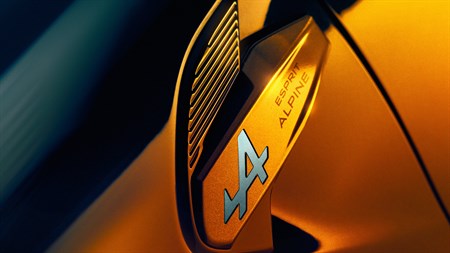 Podrobnost značke Esprit Alpine z modrim logotipom A na rumenem karoserijskem delu Renault Captur.