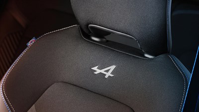 Sedež vozila z vezenim logotipom "Alpine A" in modro-rdečimi šivi.