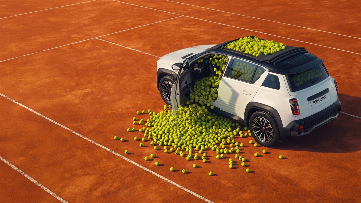 Beli Renault 4 Roland Garros posebne izdaje na rdeči peščeni teniški podlagi z množico teniških žogic, ki se sipljejo iz odprtih stranskih vrat in prekrivajo streho vozila.