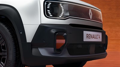 Detajl sprednjega dela Renault 4 z LED žarometi in logotipom na rdeči peščeni podlagi.