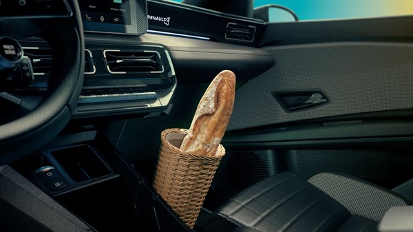 Notranjost Renault 4 E-Tech Electric, ob sovoznikovem sedežu na tleh pletena košara z baguetto.