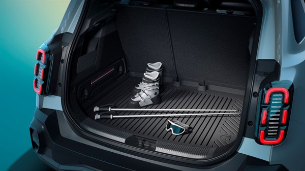 Prtljažnik Renault 4 E-Tech Electric z parom smučarskih čevljev, smučarskima palicama in smučarskimi zaščitnimi očali.