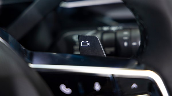 Ročica za zaviranje na volanu Renault 4 E-Tech Electric z ikono baterije in puščico.