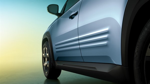 Detajl bočne strani modro-sivega Renault 4 E-Tech Electric, vidne reliefne linije na vratih.