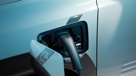 Polnjenje električnega vozila Renault – podrobnost priključka za polnjenje z odprtim pokrovom, ki prikazuje dizajn in logotip znamke.