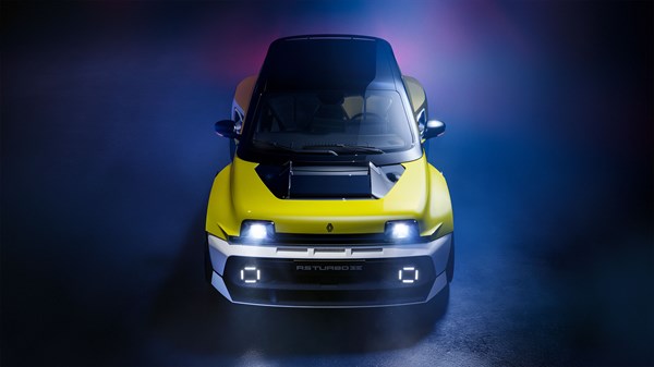 Sprednji pogled na Renault 5 Turbo 3E z vidnimi kvadratnimi LED žarometi in črnim pokrovom motorja, osvetljen z modro in vijolično svetlobo.