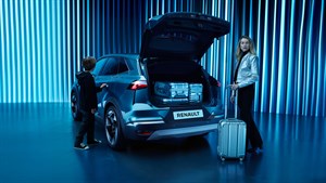 Renault SUV z odprtim prtljažnikom, napolnjenim s kovčki, stoji v futurističnem modrem prostoru. Ob vozilu sta ženska z majhnim kovčkom in otrok, ki sega proti vratom vozila.