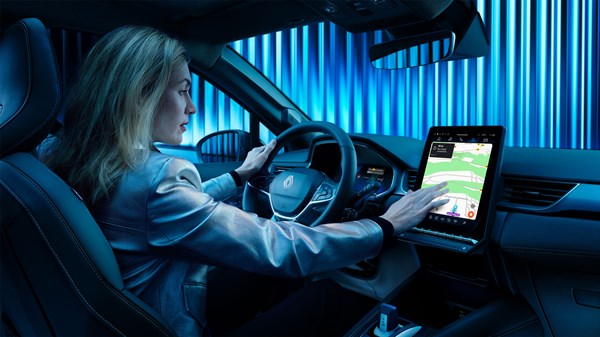 Ženska sedi za volanom Renault Symbioz in upravlja osrednji zaslon na dotik.