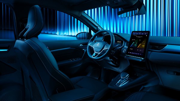 Notranjost vozila Renault, osvetljena z modro svetlobo, poudarja digitalni zaslon na sredinski konzoli in volan s sodobnim dizajnom.