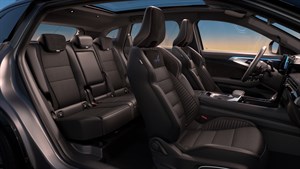 Razkošna notranjost vozila Renault Austral z usnjenimi sedeži, prostorno kabino in panoramsko streho ob sončnem zahodu.