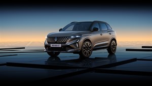 Sodoben SUV Renault Austral z dinamično obliko in LED žarometi, parkiran na odsevni površini ob sončnem zahodu.