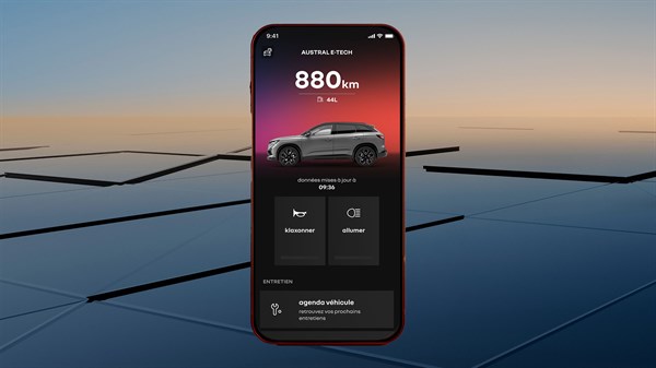 Prikazan pametni telefon z odprto aplikacijo My Renault, kjer je vidno vozilo v ozadju na zaslonu telefona in prikaz dosega kilometrov.