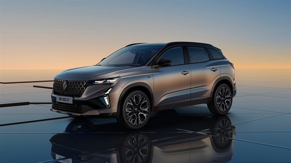 Sivi Austral parkiran na stekleni površini ob sončnem zahodu, prikazan iz sprednje bočne perspektive.