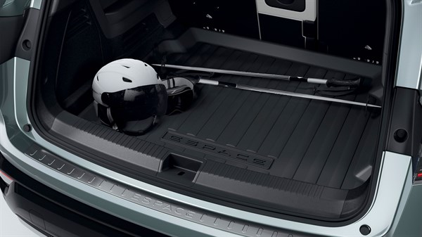 Pogled na prtljažnik Renault Espace z inox zaščito roba prtljažnega prostora in shranjeno športno opremo, vključno s čelado in palicama.