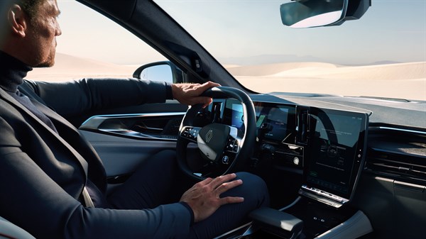 Moški v Renault Espace upravlja vozilo z vklopljeno navigacijo na sredinskem zaslonu.