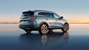 Renault Espace v svetlo modro-srebrni barvi, pogled od zadaj-desno med sončnim zahodom.