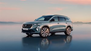 Sodobni Renault Austral je parkiran na sijoči površini, ki odseva vozilo in nežno rožnato-modro nebo ob sončnem zahodu. 