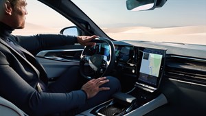 Moški vozi Espace z moderno notranjostjo, poudarjeno z velikim pokončnim zaslonom na dotik z navigacijo.