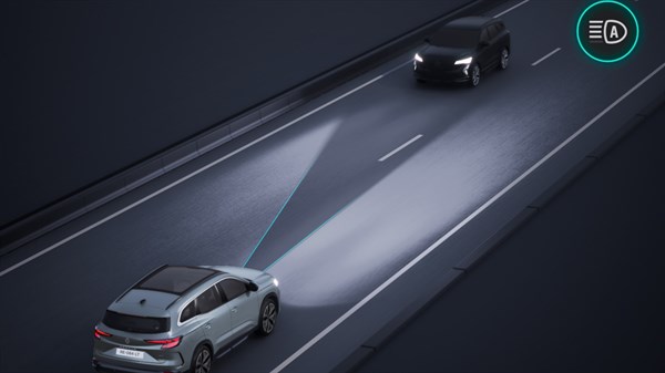 Renault Espace vozi ponoči, pred njim je osvetljen del ceste, nasproti prihaja drugo vozilo, prikazana je grafika žarometov.